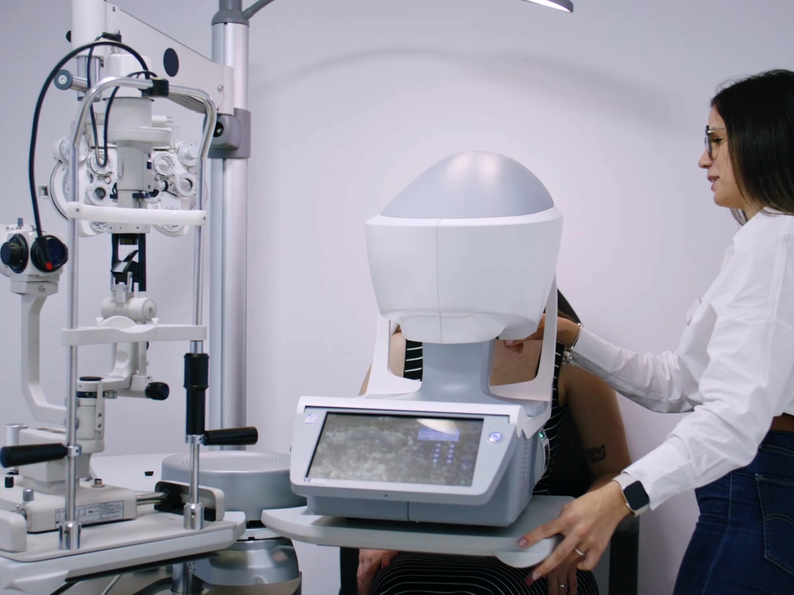 Optometrista de LUPER colocando a una paciente en el equipo de examen visual del gabinete